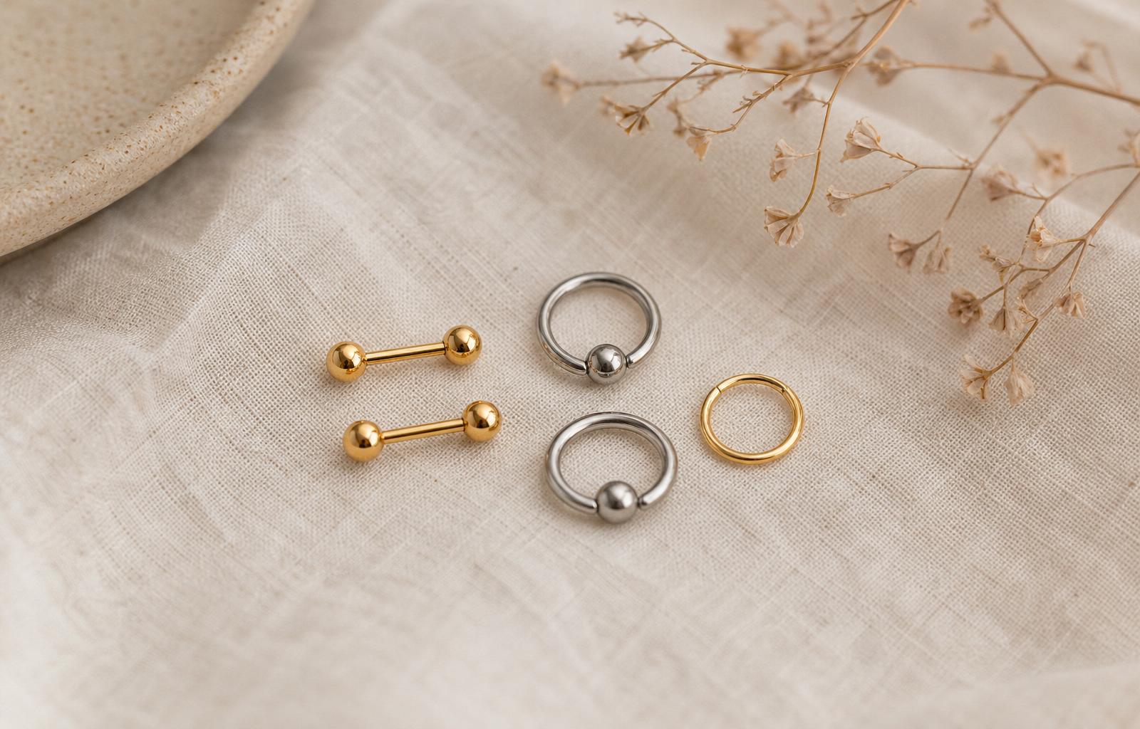 Gioiello barbell in oro su tessuto naturale, stile editoriale